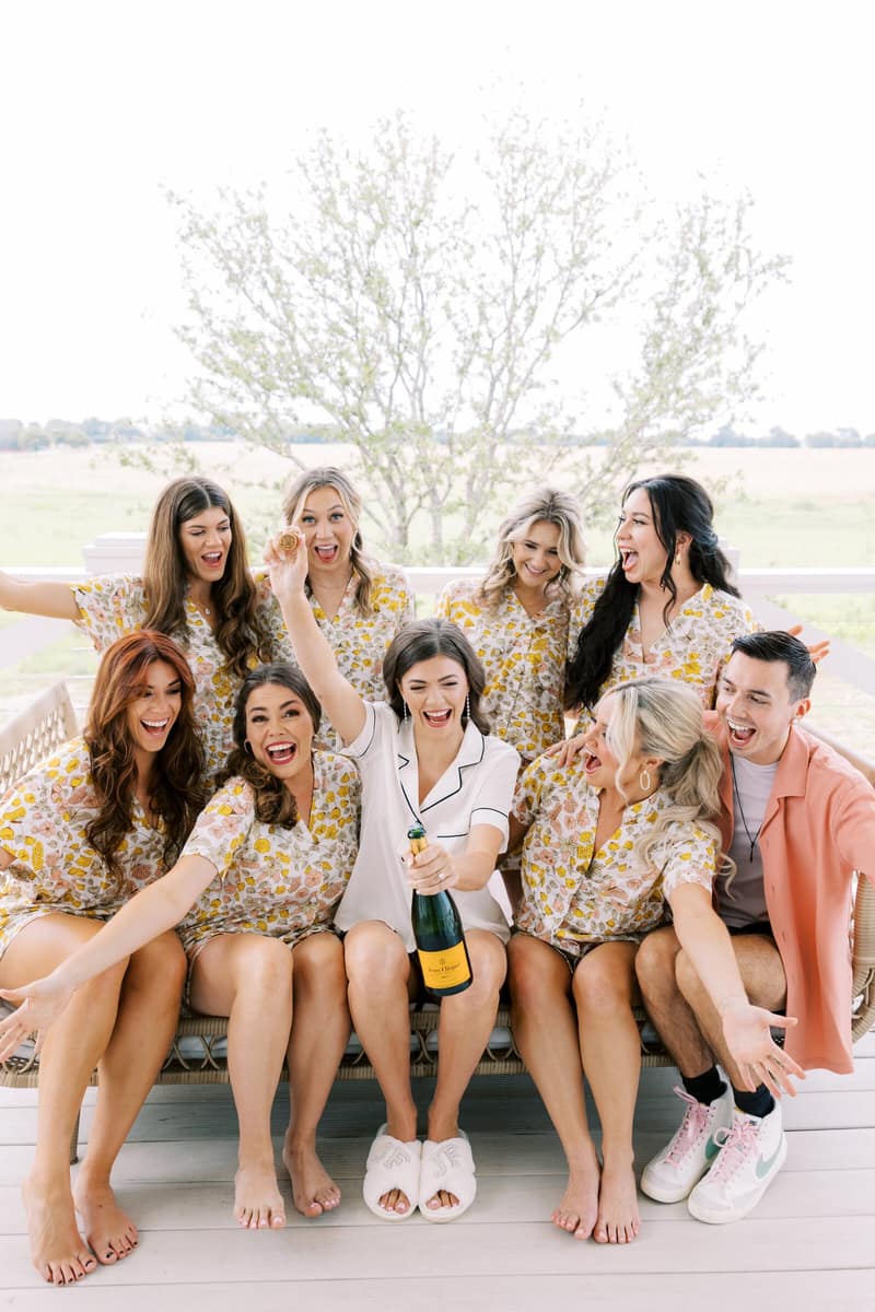 Bridal party in matching pyjamas with champagne before the ceremony