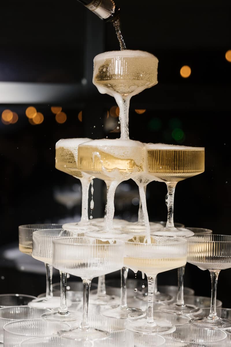Close-up of champagne cascading down a tower of coupe glasses at a Dallas wedding