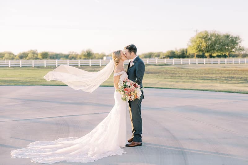 Couple embracing in an open Texas field at golden hour