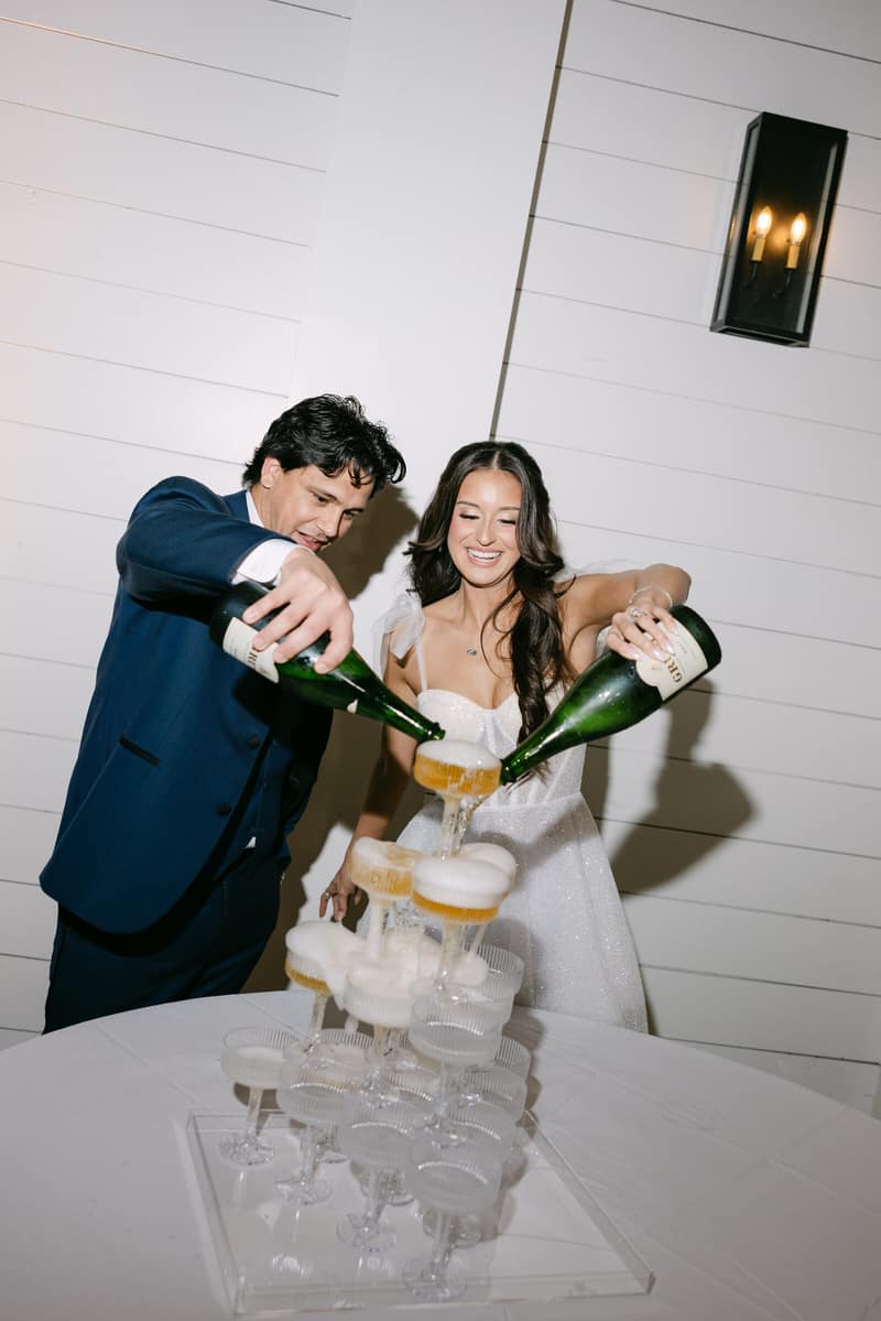 Bride and groom pouring the first glass of a champagne tower