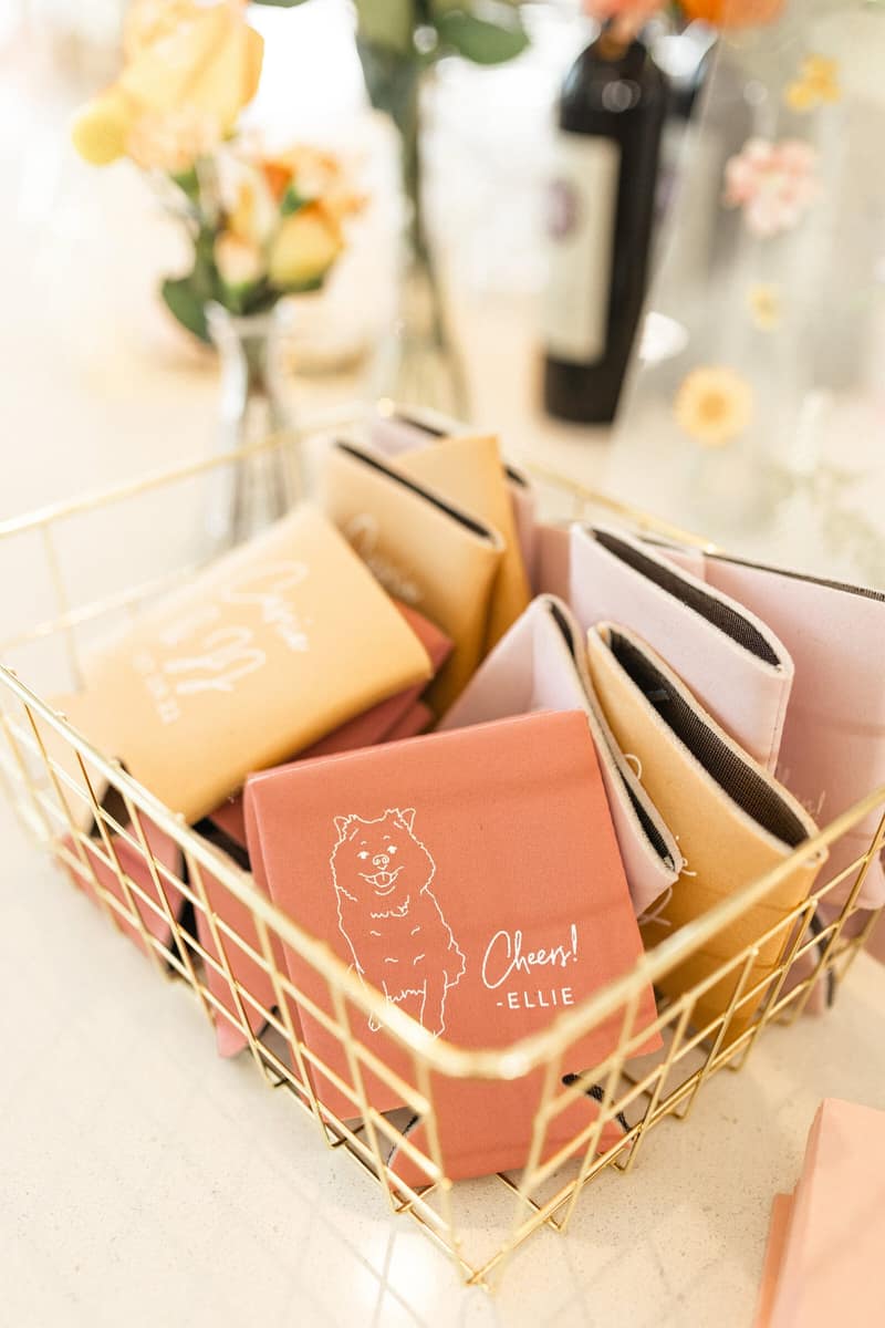 Personalised wedding koozies in a gold basket on a bar detail table