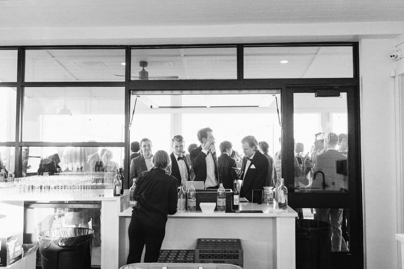 Guests gathered at the bar, photographed in black and white