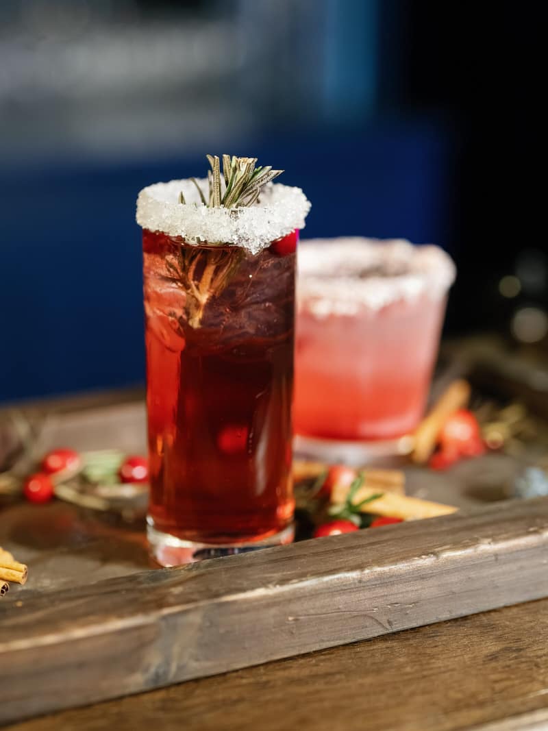 Holiday cocktail with a sugared rim and rosemary garnish