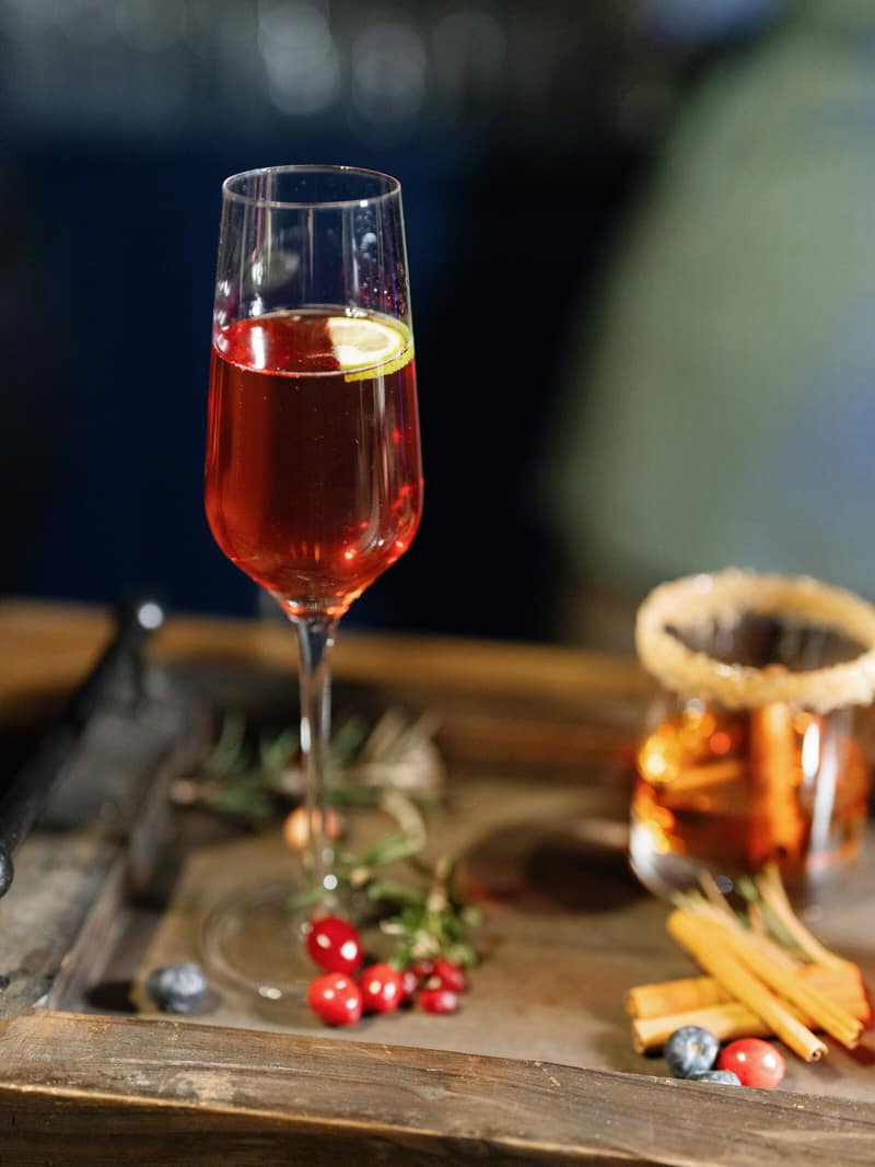 Holiday cocktails including a smoked old fashioned on a serving board