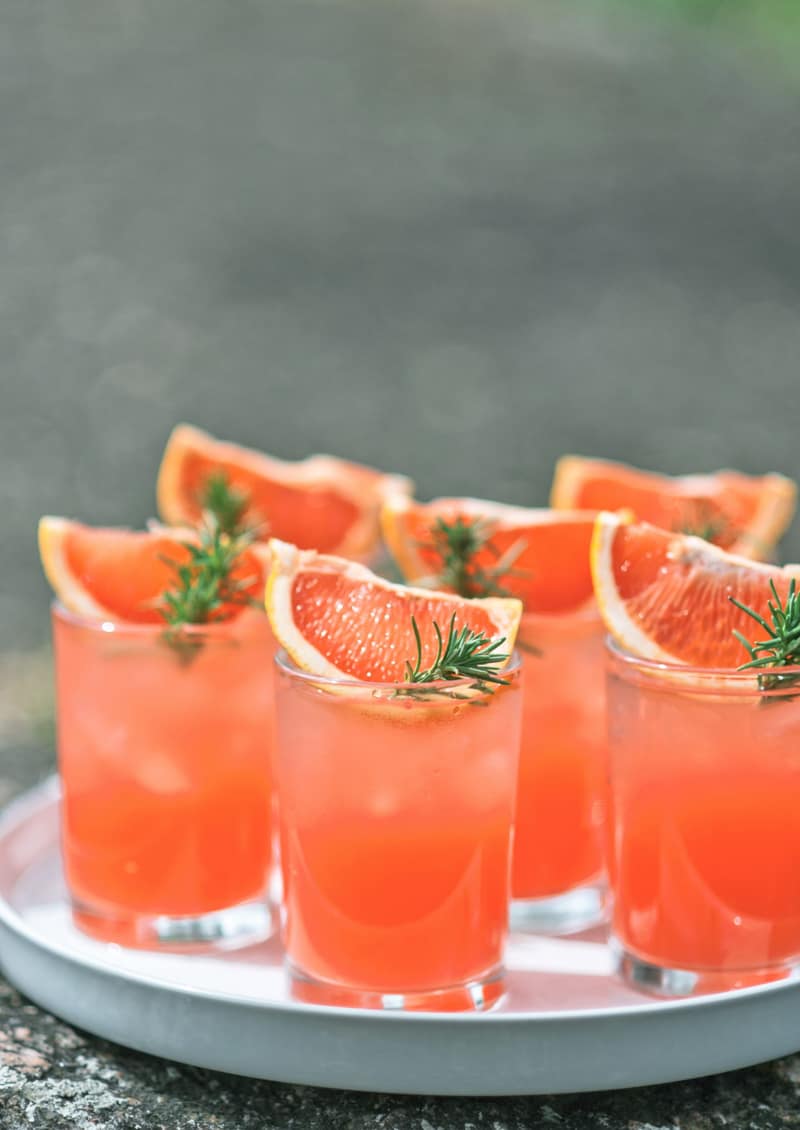 Tray of grapefruit palomas garnished with dehydrated citrus