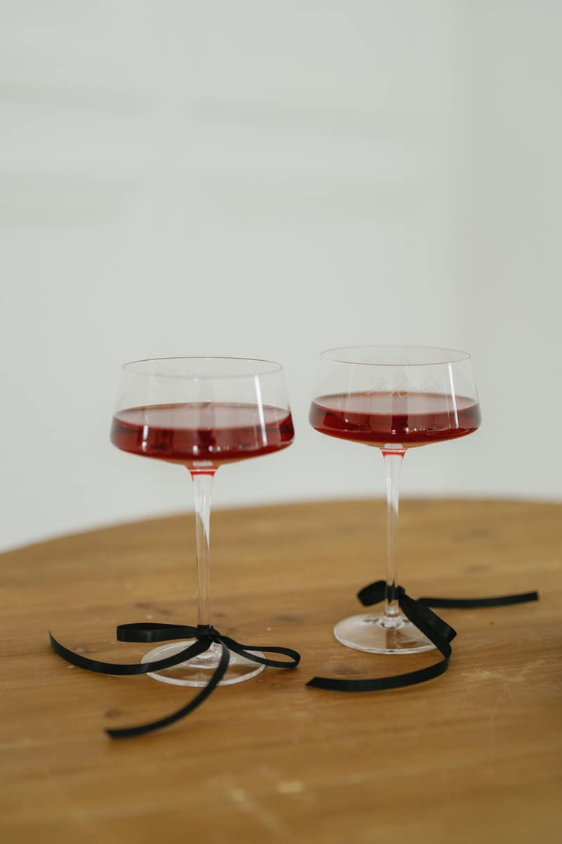 Two glasses of house red wine on a wooden table