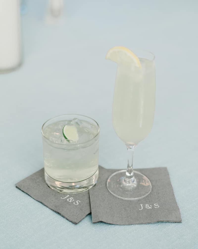 A signature cocktail and a champagne flute on monogrammed cocktail napkins