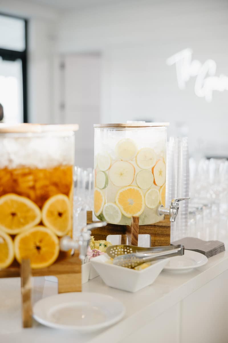 Specialty lemonade dispensers with sliced citrus on a non-alcoholic bar