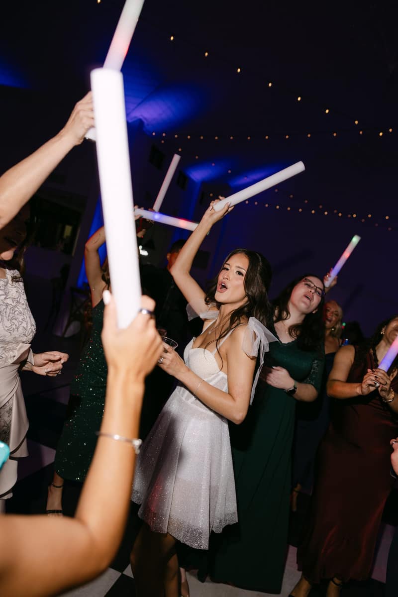 Guests dancing under string lights late in a wedding reception